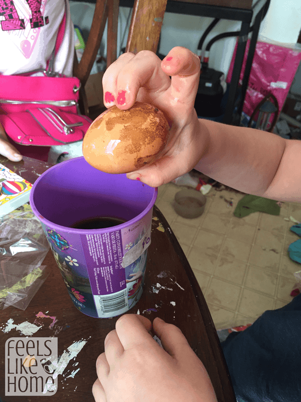 a hand holding a brown egg