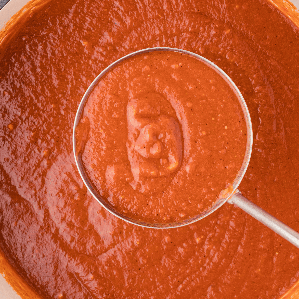 homemade Mexican enchilada sauce in a ladle 