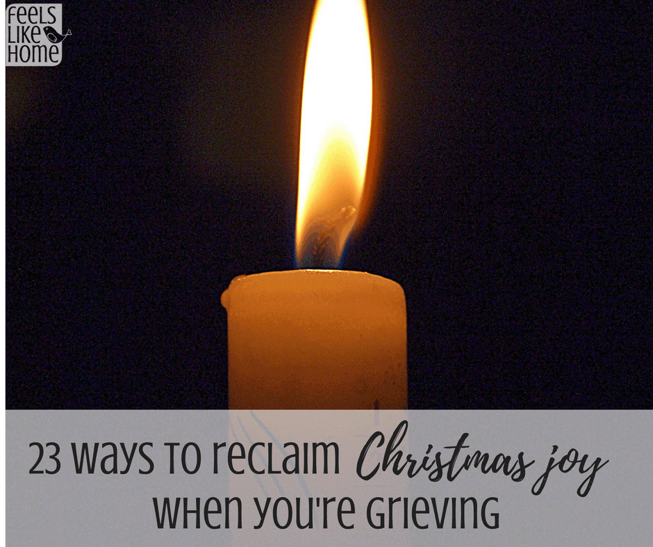 a candle in the dark with the title "23 ways to reclaim Christmas joy when you're grieving"