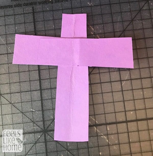 A close up of a pink paper cross