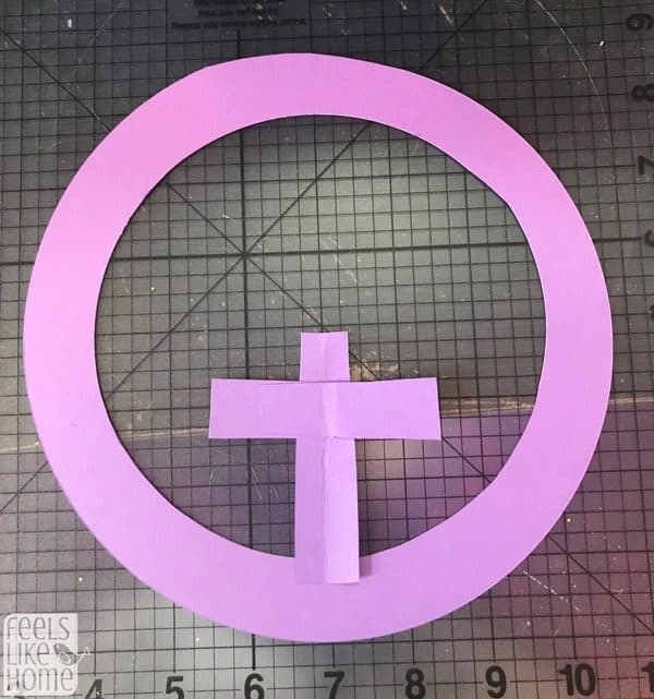 A pink paper circle with a cross at the bottom 