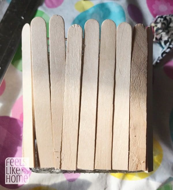 Gluing popsicle sticks to the candle holder