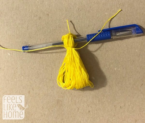 Tie a knot around the top of the bundle of string