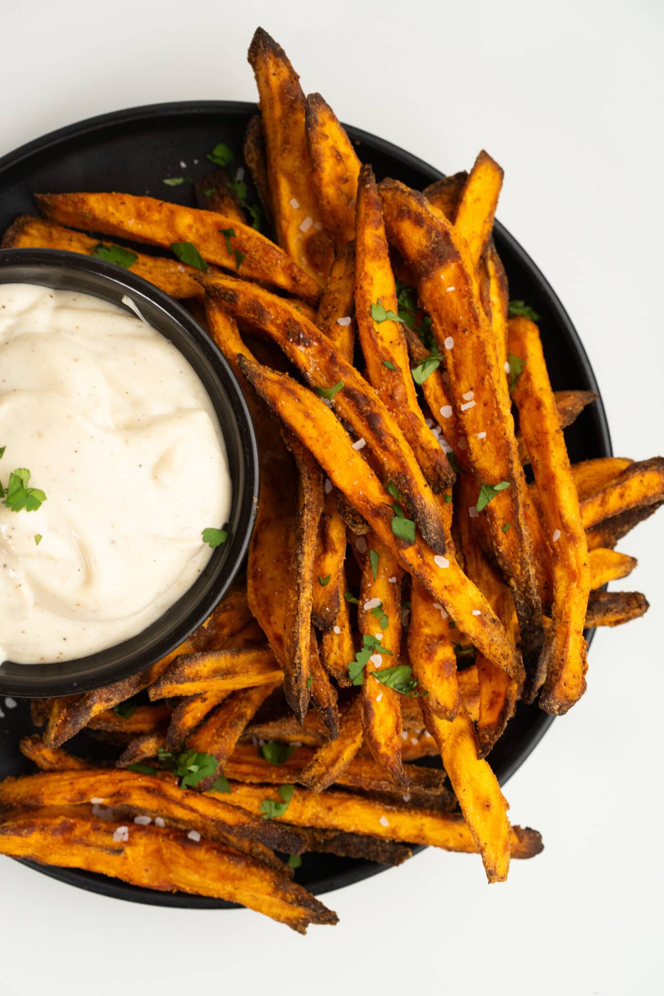 Crispy Air fryer sweet potatoes all served up in a plate with dipping sauce