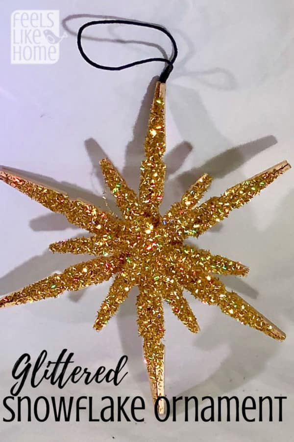 A clothespin snowflake all covered in glitter