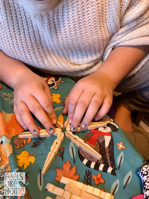 a girl glueing clothespins together