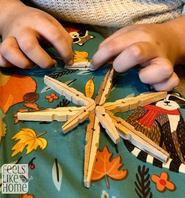 a girl glueing clothespins together