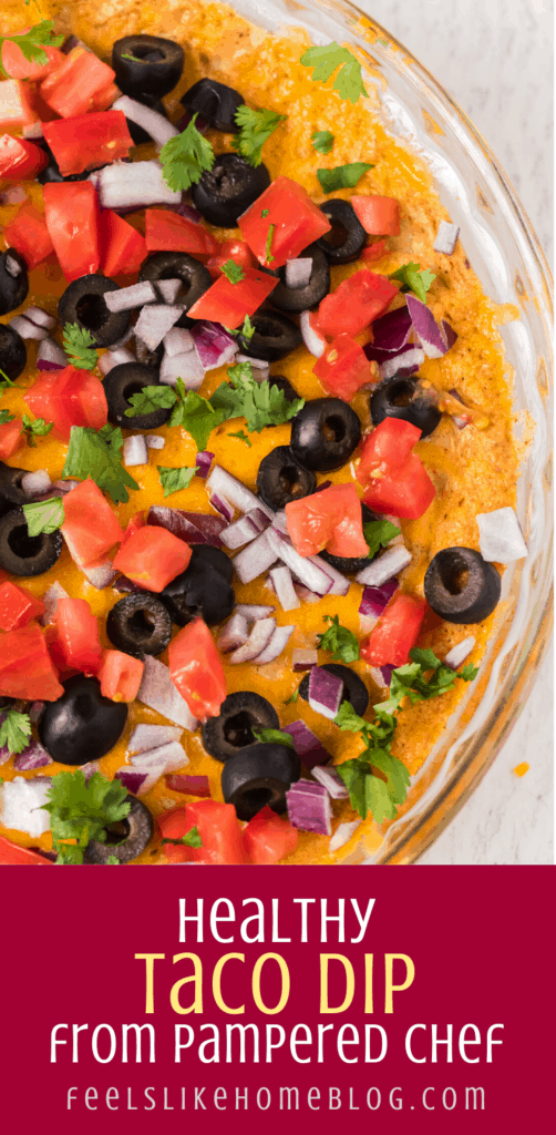 taco dip topped with olives, tomatoes, onions, and cilantro