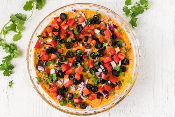 healthy taco dip with diced tomatoes, black olives, onion, and cilantro