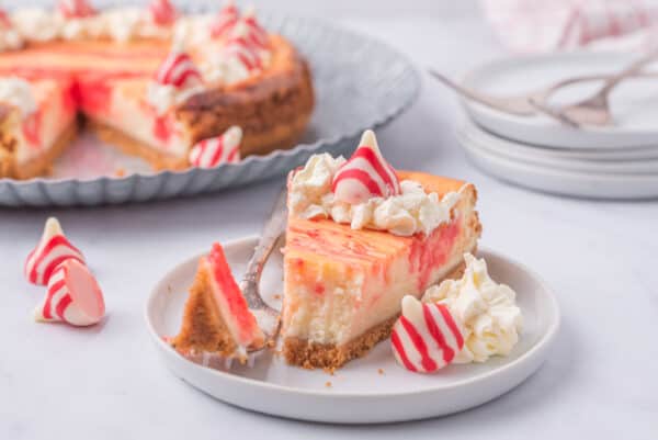 one slice of cheesecake with candy cane kisses on top