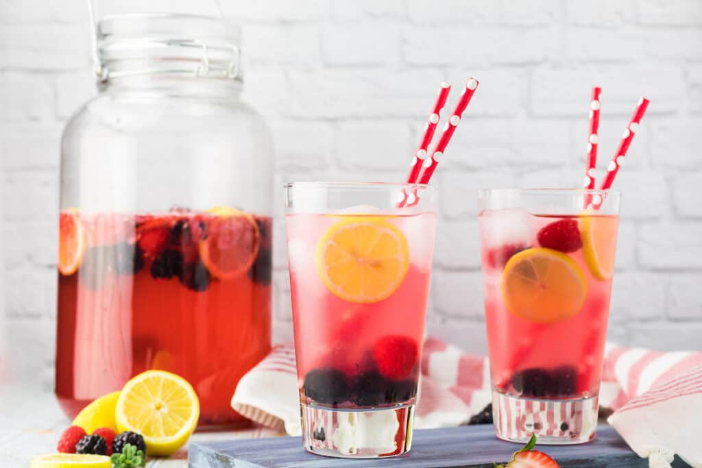 a pitcher of berry lemonade and two glassess