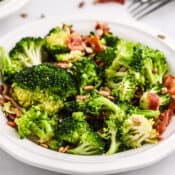 a bowl of broccoli salad in a white dish