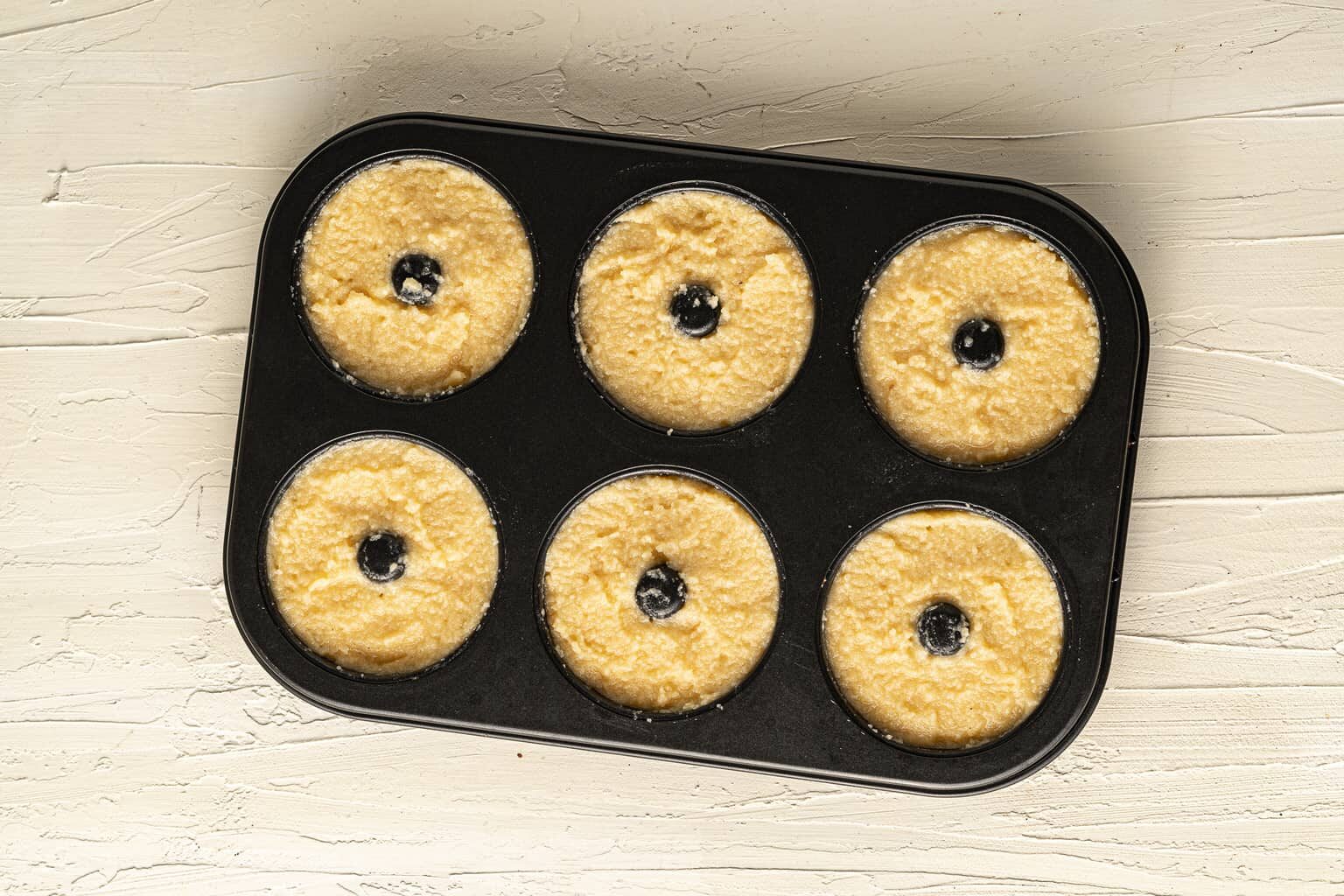 raw almond flour donuts in a baking pan