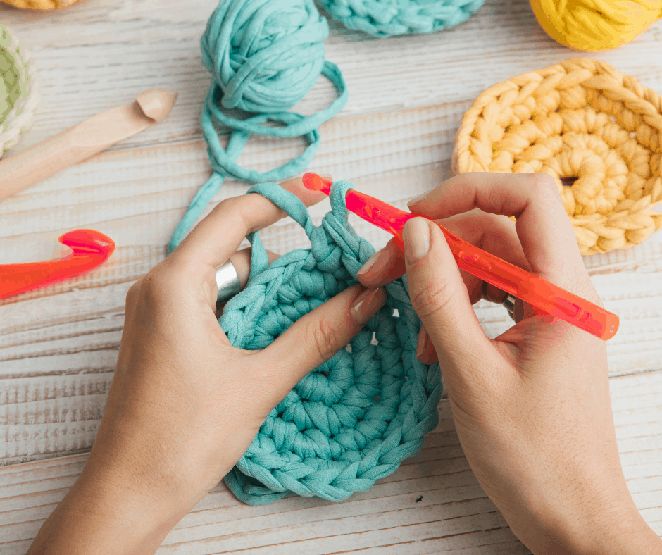 a woman crocheting a blue circle