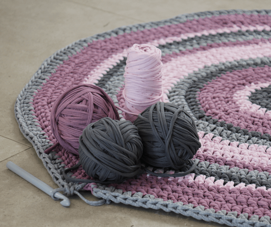 balls of yarn with a crocheted rug