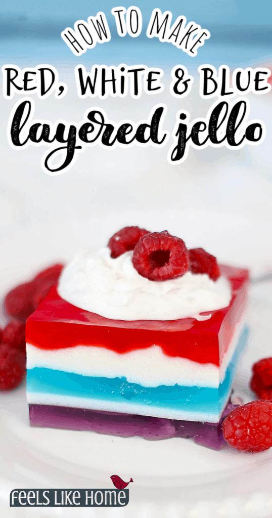 one square of layered jello on a plate with fresh raspberries