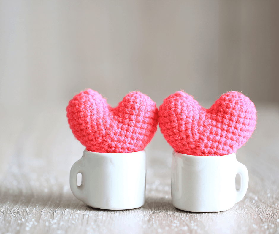 two tiny pink crocheted hearts in white cups
