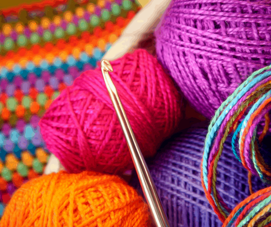 a crochet hook with brightly colored yarns and threads