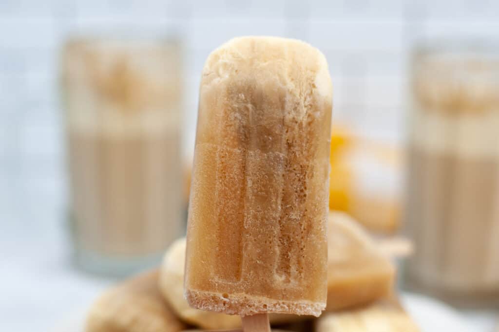 a single root beer float popsicle with vanilla ice cream