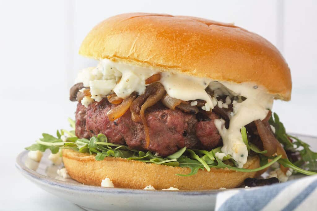 homemade burger with aioli dripping down over it