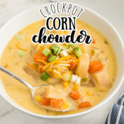 crockpot corn chowder with carrots and cheese in a white bowl