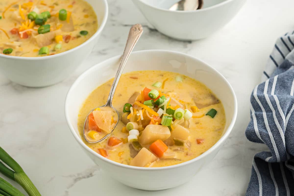 crockpot corn chowder in a white bowl with a spoon