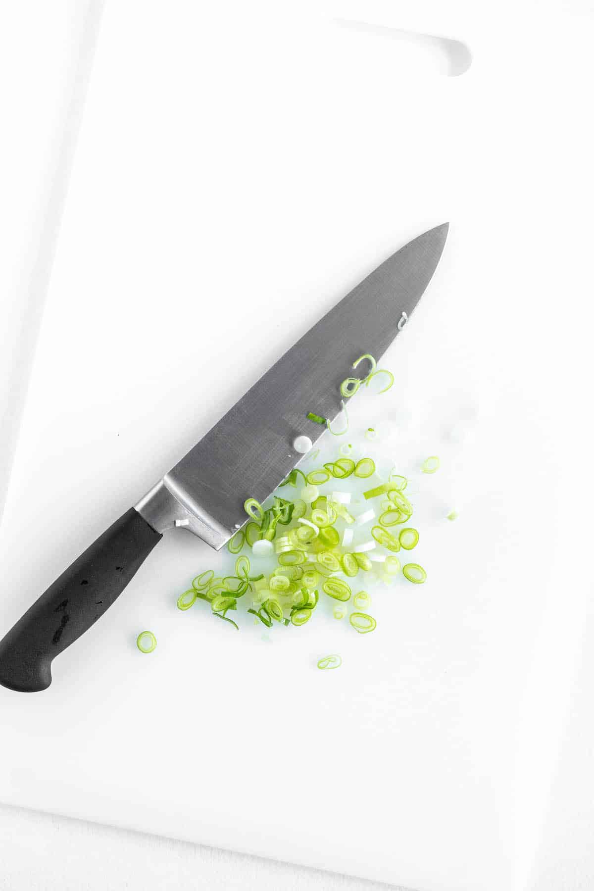 sliced scallions on a white cutting board