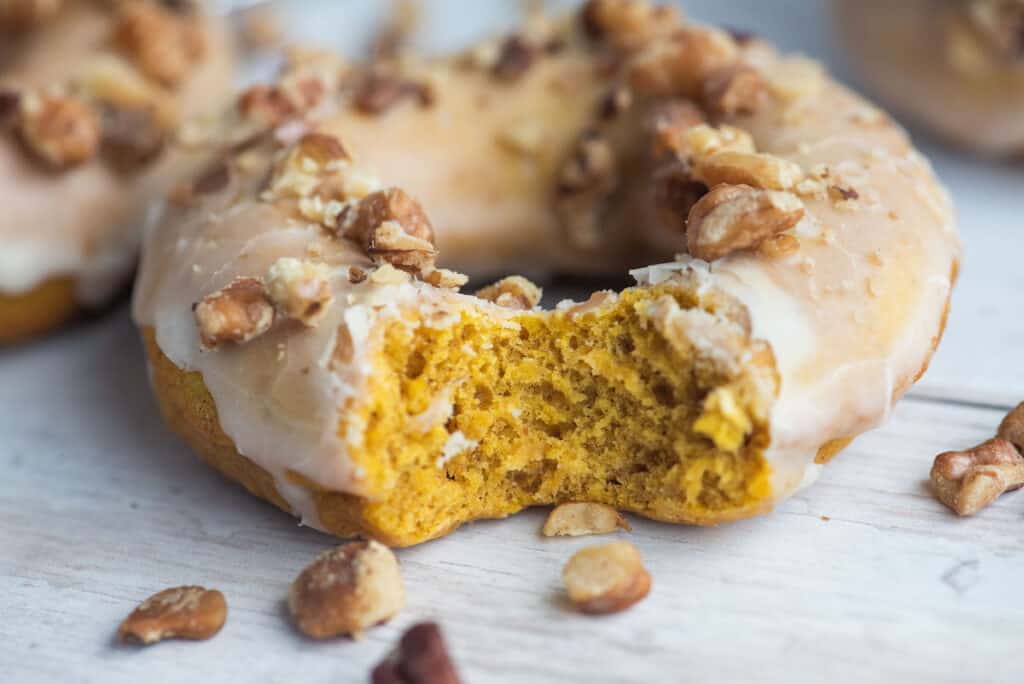 a pumpkin spice donut with a bite out of it