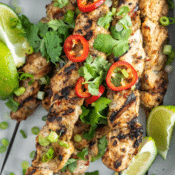 jerk chicken skewers topped with fresh cilantro and hot peppers