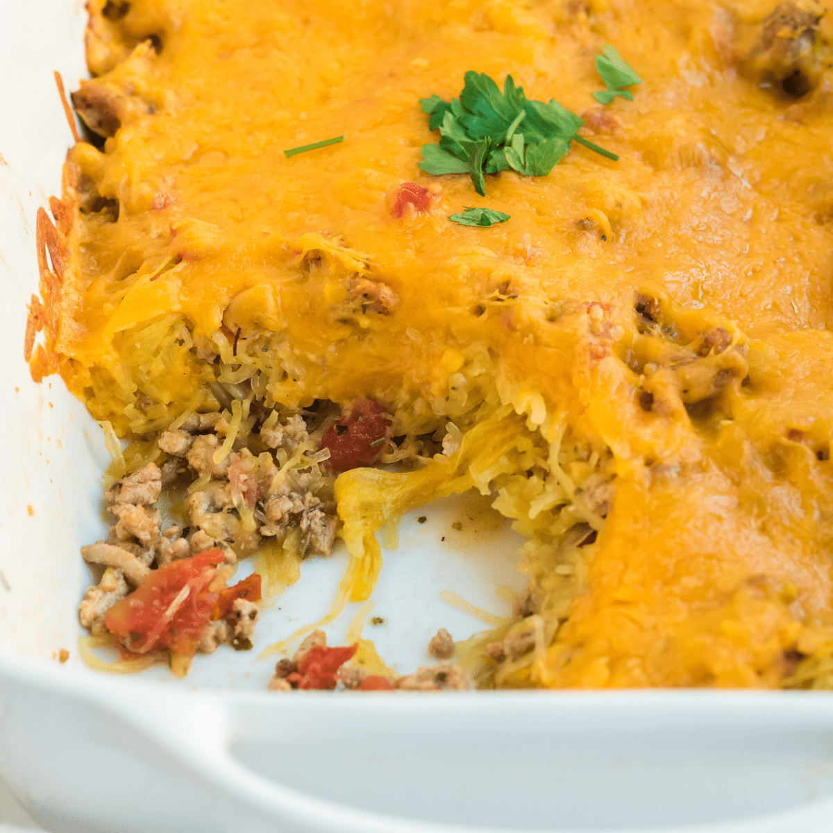 spaghetti squash with ground beef and tomatoes in a casserole dish