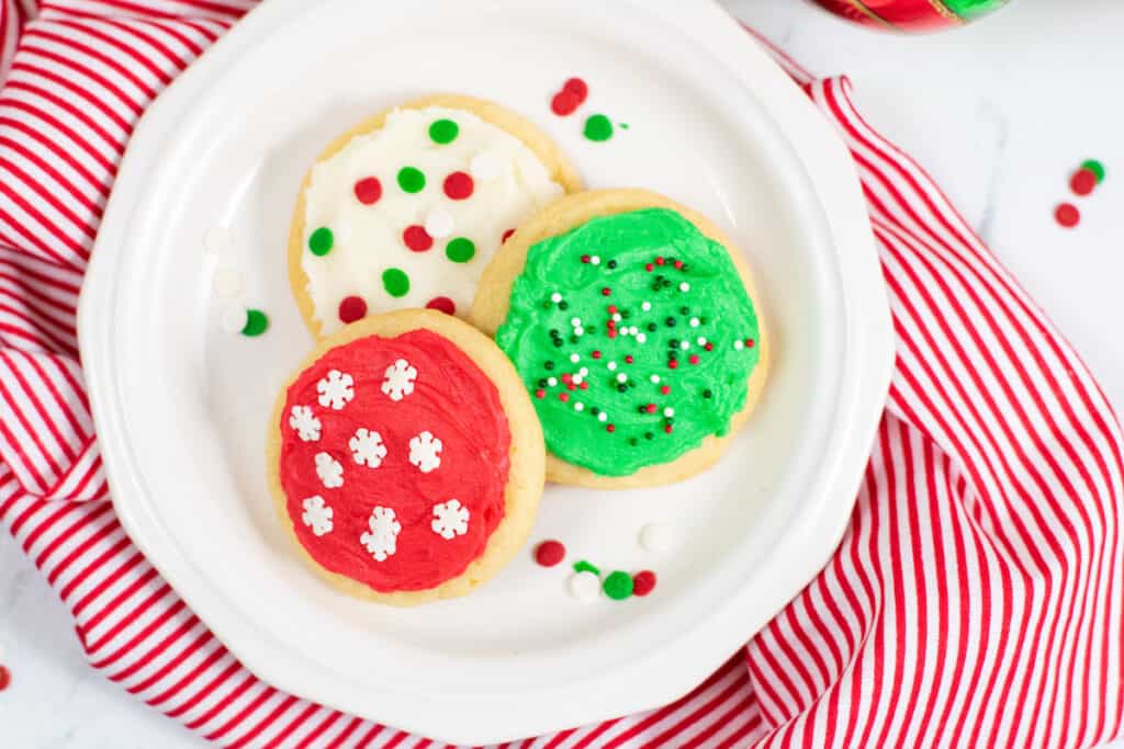 3 frosted sugar cookies on a small white plate