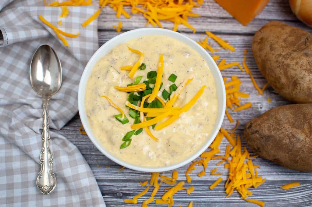 a bowl of cheeseburger soup with a spoon and napkin