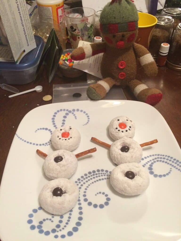 Elf on the Shelf makes snowmen out of powdered donuts