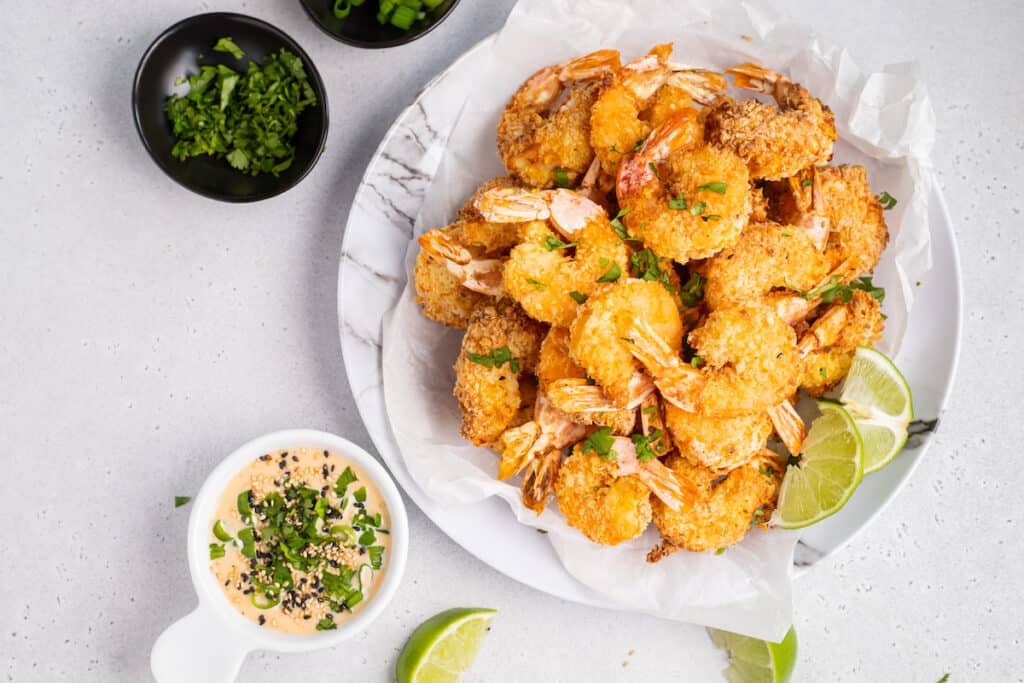 a plate of coconut shrimp with dipping sauce