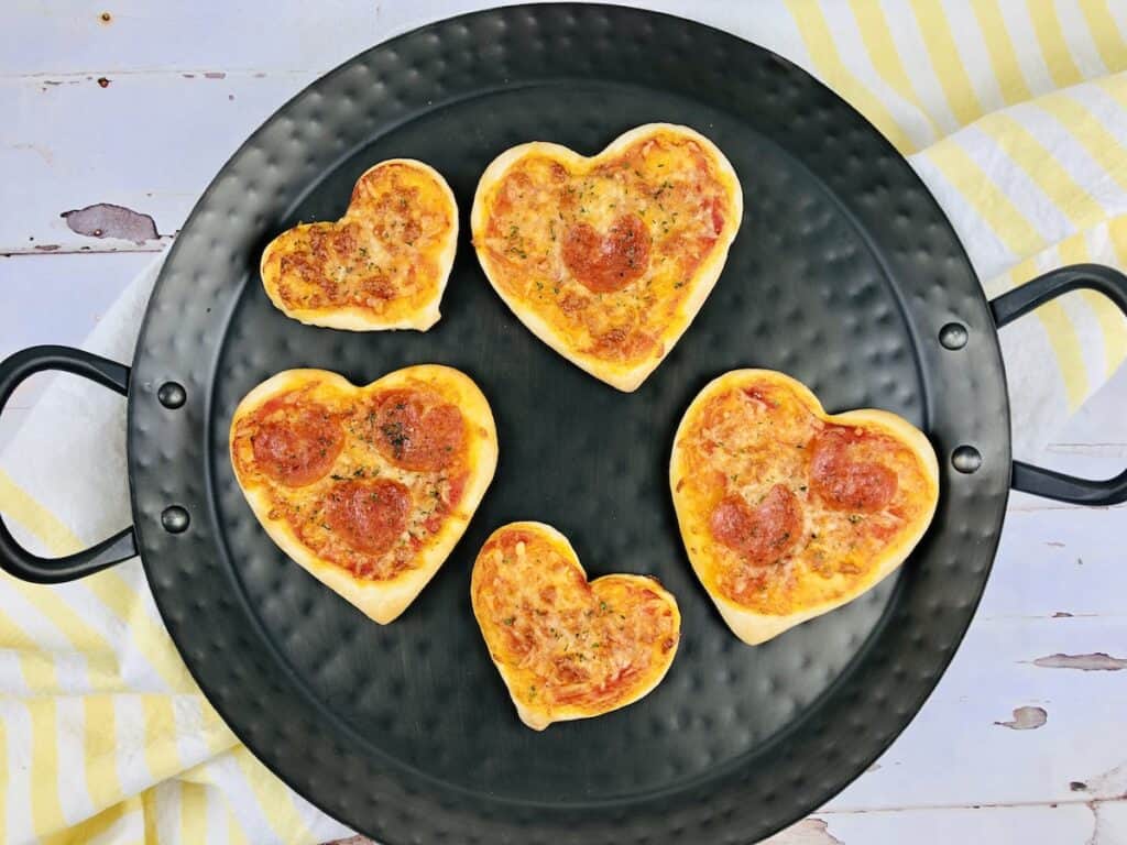 cooked heart shaped pizzas on a black plate