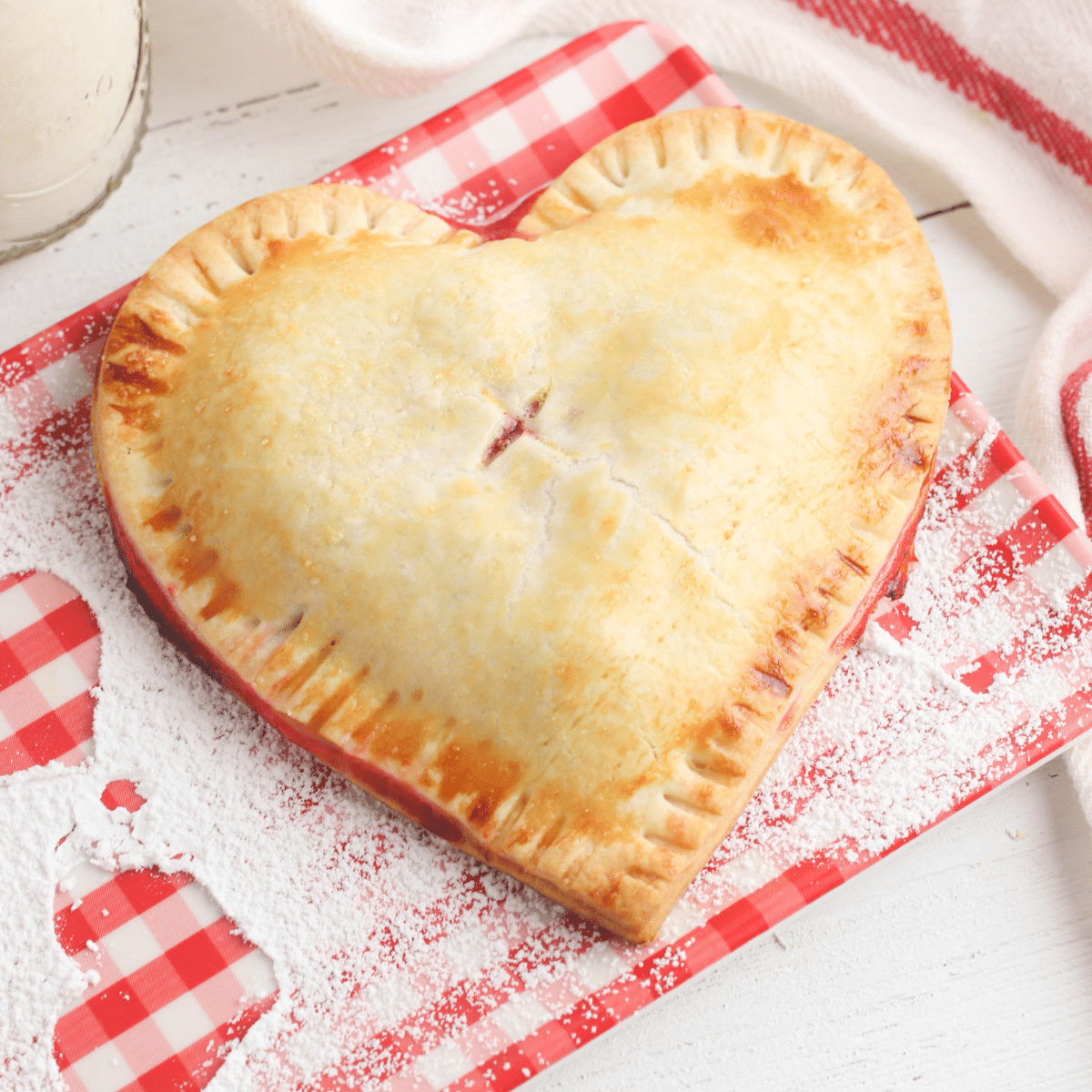 heart-shaped cherry hand pie on a red and white napkin