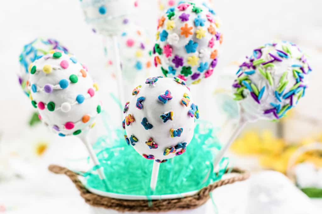 a bunch of Easter cake pops standing up in a cup