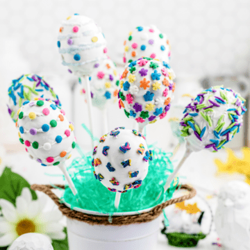 a bunch of Easter egg cake pops standing up in a white mug