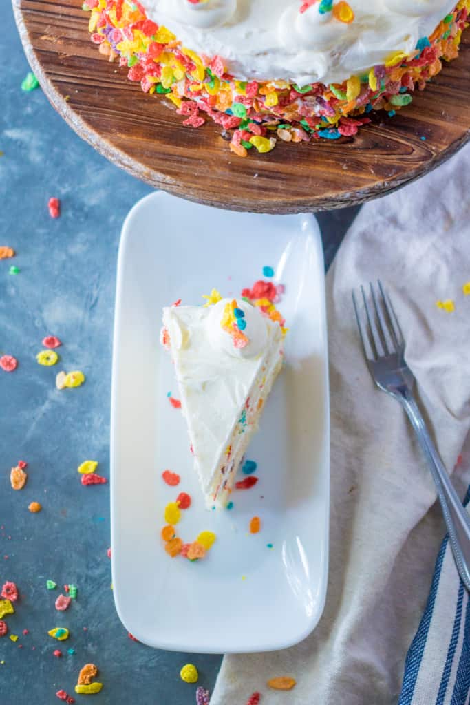 one slice of Fruity Pebbles cake on a white plate