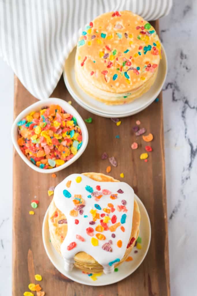 two stacks of Fruity Pebbles pancakes on a cutting board