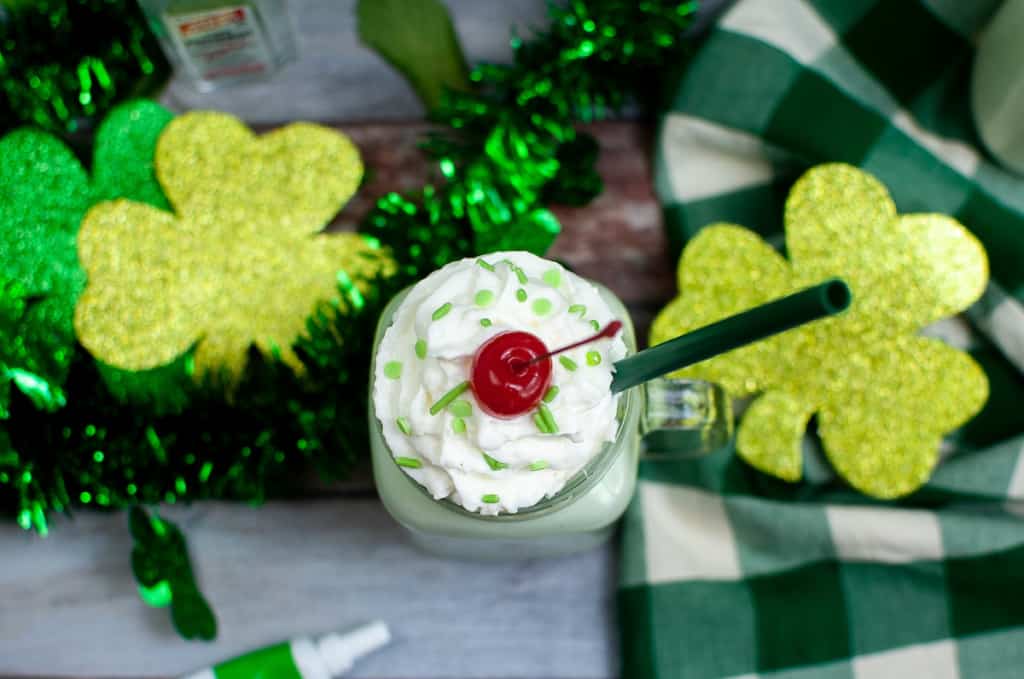 a shamrock shake with whipped cream, sprinkles, and a cherry