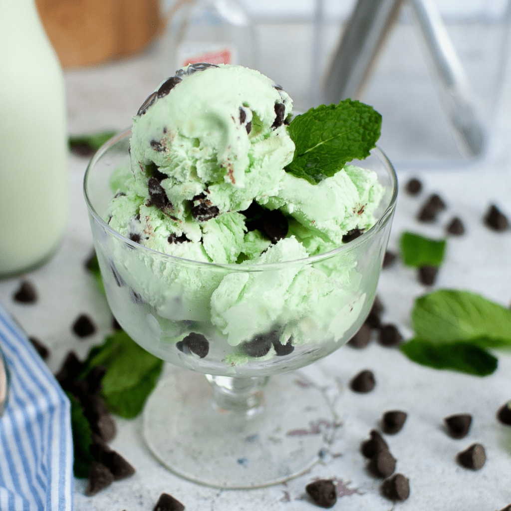 a glass bowl full of homemade no churn mint chocolate chip ice cream