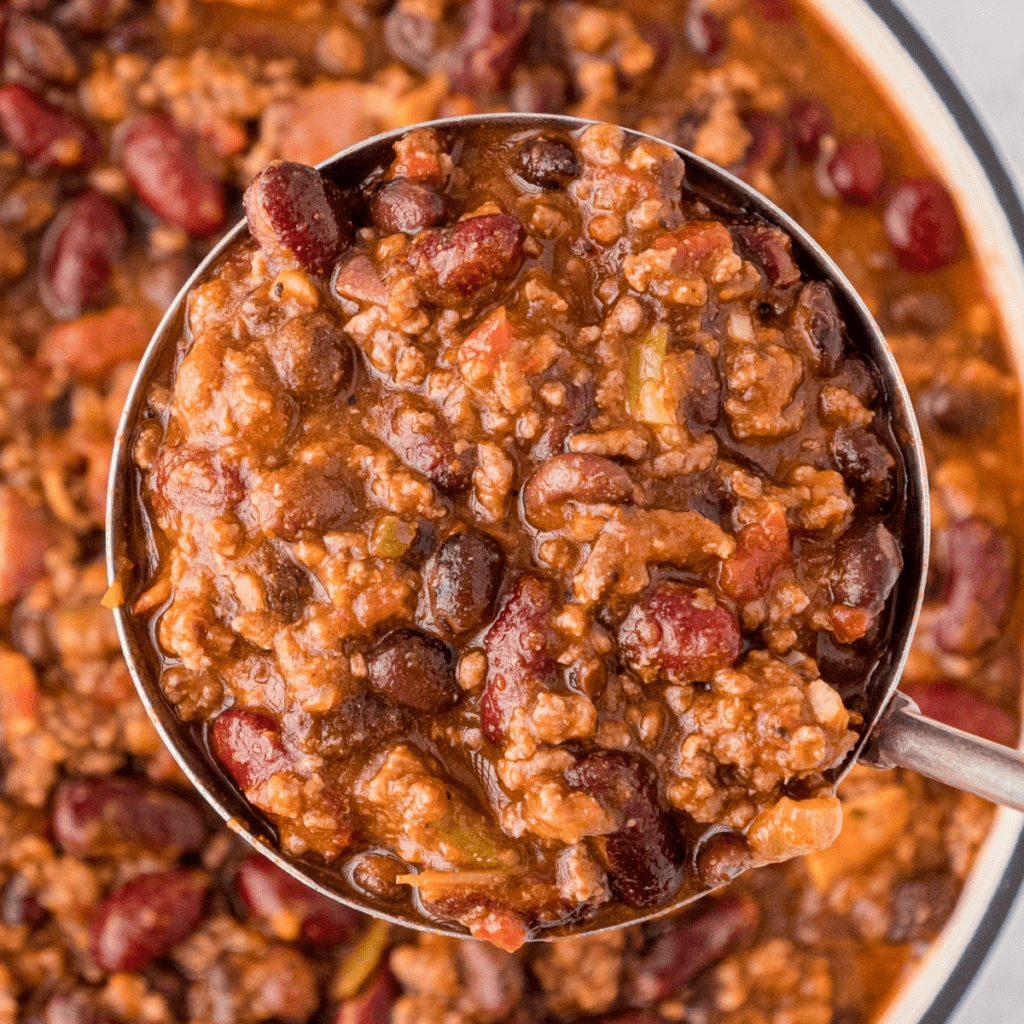 World's Best Chili with Bacon in a large ladle
