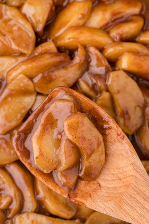 a close up of fried apples on a wooden spatula