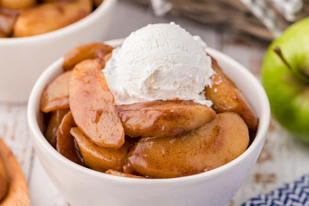 fried apples in a dish with whipped cream