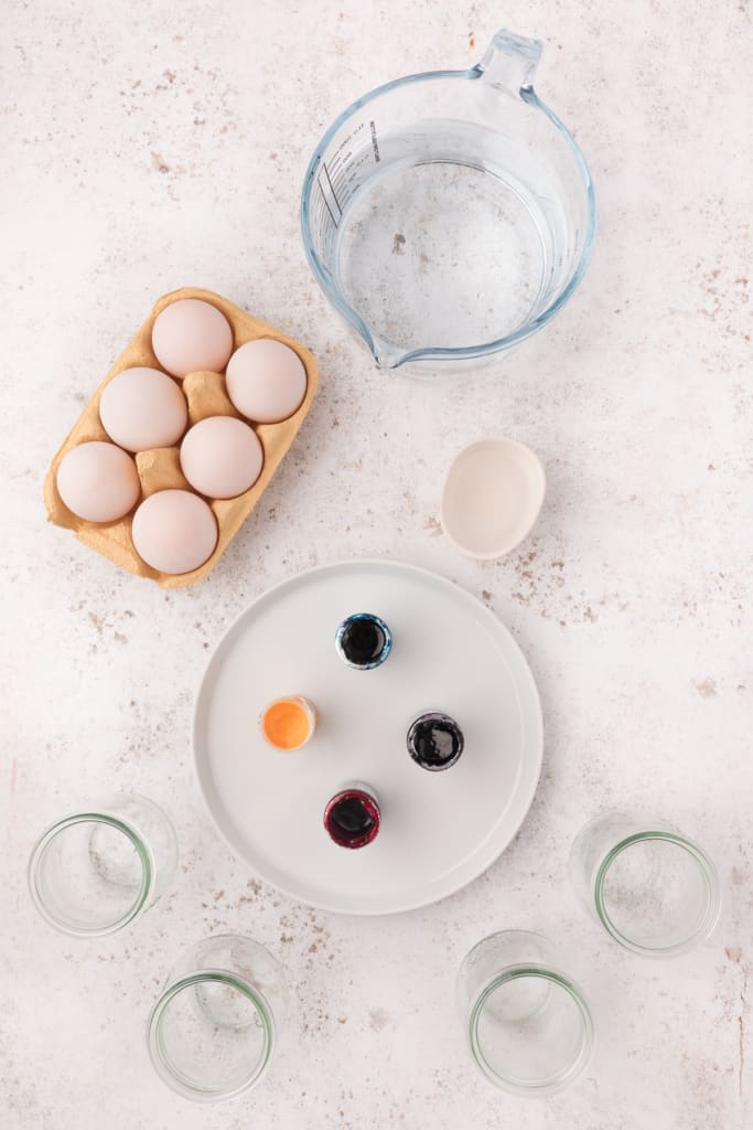 egg dyeing ingredients - eggs, hot water, food color, and small glass jars