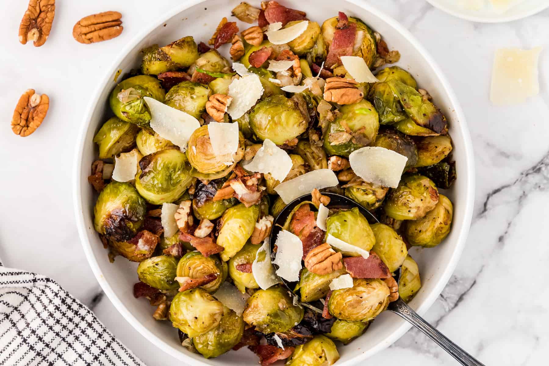 easy roasted brussels sprouts with bacon, pecans, and Parmesan cheese in a white bowl