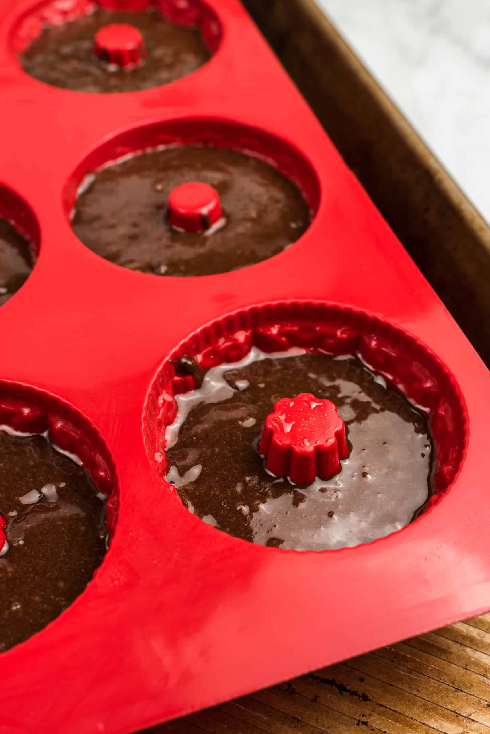 a close up of chocolate brownie batter in a mini bundt pan