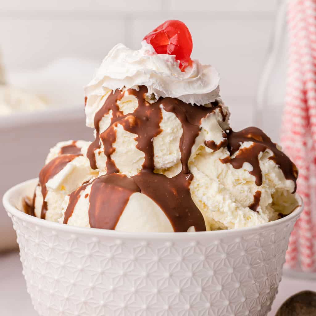 an ice cream sundae with chocolate sauce, whipped cream, and a cherry