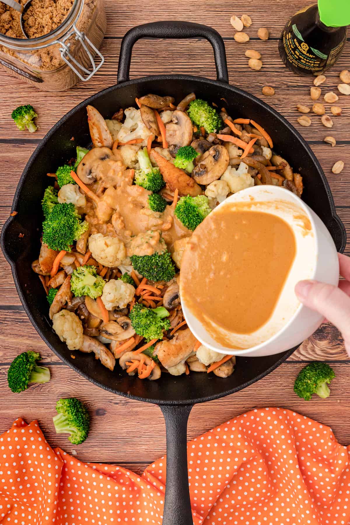 pour the peanut stir fry sauce over the chicken and veggies in the skillet